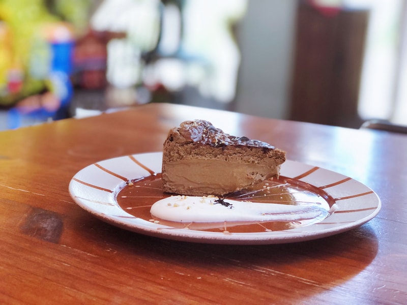 伯爵茶蛋糕切片，外皮微焦酥脆，內層濕潤綿密，茶香濃郁不膩。搭配鮮奶油可增添滑順口感，但不加時更能品味茶香的純粹層次。擺盤溫柔，適合午後療癒時光。