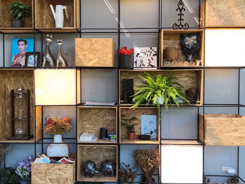 Arc Cafe二樓展示牆，由多個方格組成。擺放金屬雕像、插畫、書法、乾燥花與書籍。營造層次感與溫暖氛圍。