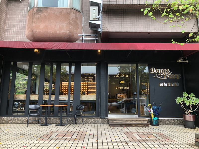 波赫士領地精品咖啡館明水店|台北大直不限時咖啡廳推薦,開心果奶霜千層必吃甜點 - 第7張圖 波赫士領地咖啡館明水店,玻璃門面與金色字體交織出靜謐氛圍,綠意點綴街角,彷彿一場文學與感官的邀請。