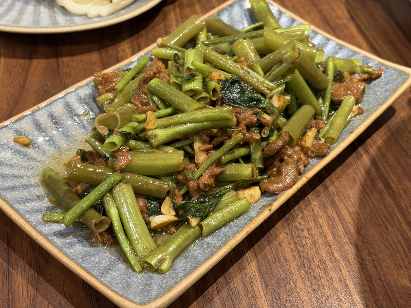 潮牛殿溫體牛創意鍋物評價|松山區美食分享・民生社區火鍋食記 - 第27張圖 台北潮牛殿火鍋配菜,熱炒空心菜搭配牛肉與蒜片,色香味俱全